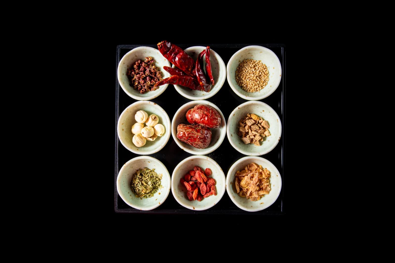 将用筷子夹起的卷羊肉放入麻辣汤与白汤双味锅的瞬间,俯拍。