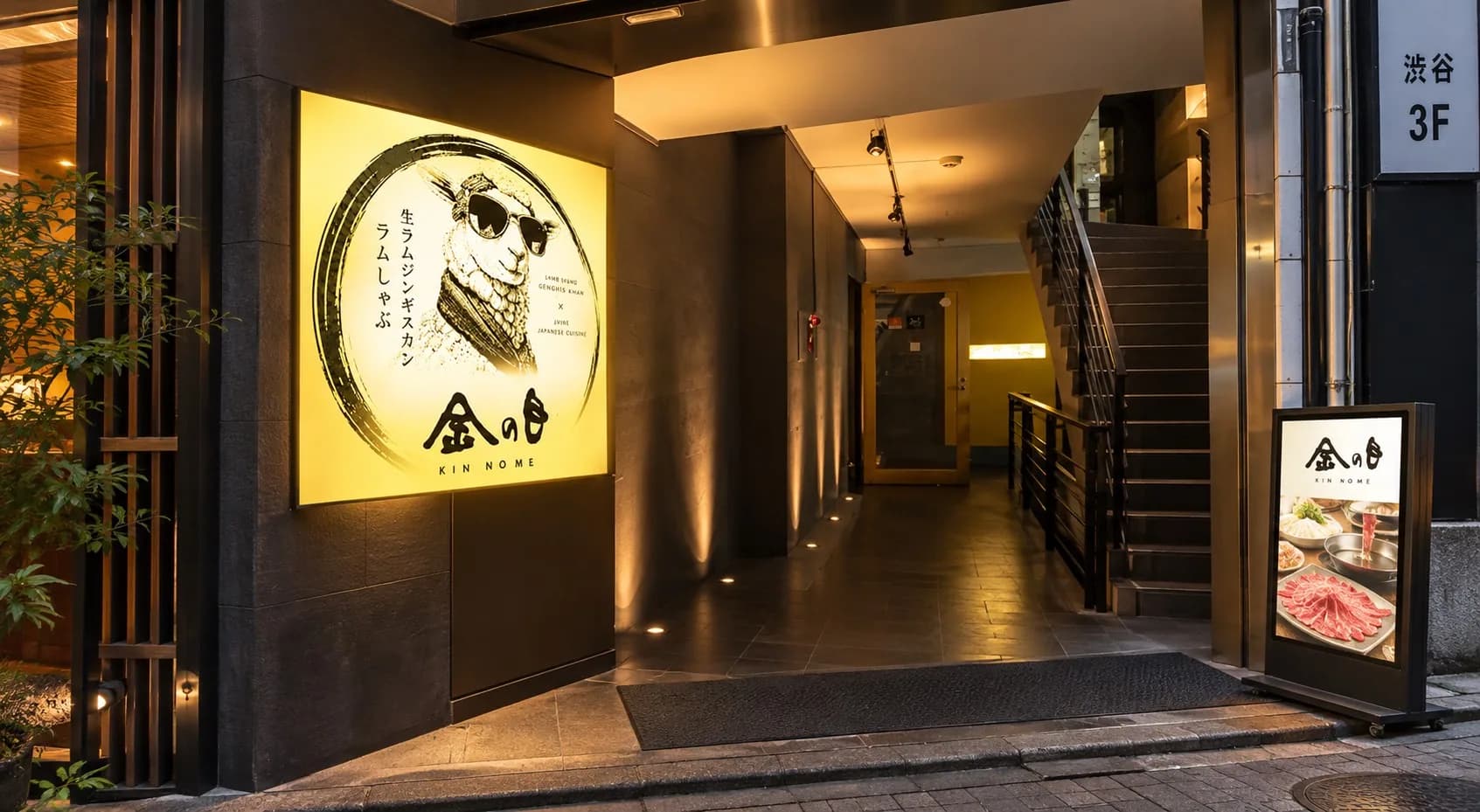 夜晚的入口。戴墨镜的羊“金之目”招牌亮着灯,可见通往内部的通道和楼梯,以及3F的指示牌