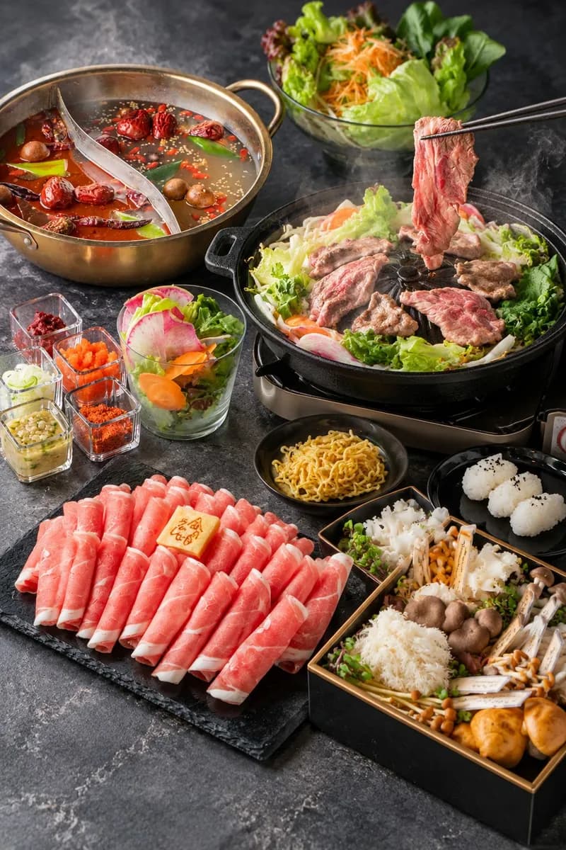 二色鍋とジンギスカン鍋を中心に、薄切りラム肉、きのこと野菜、薬味、〆の麺とおにぎりを並べた食卓。箸でラム肉を持ち上げている